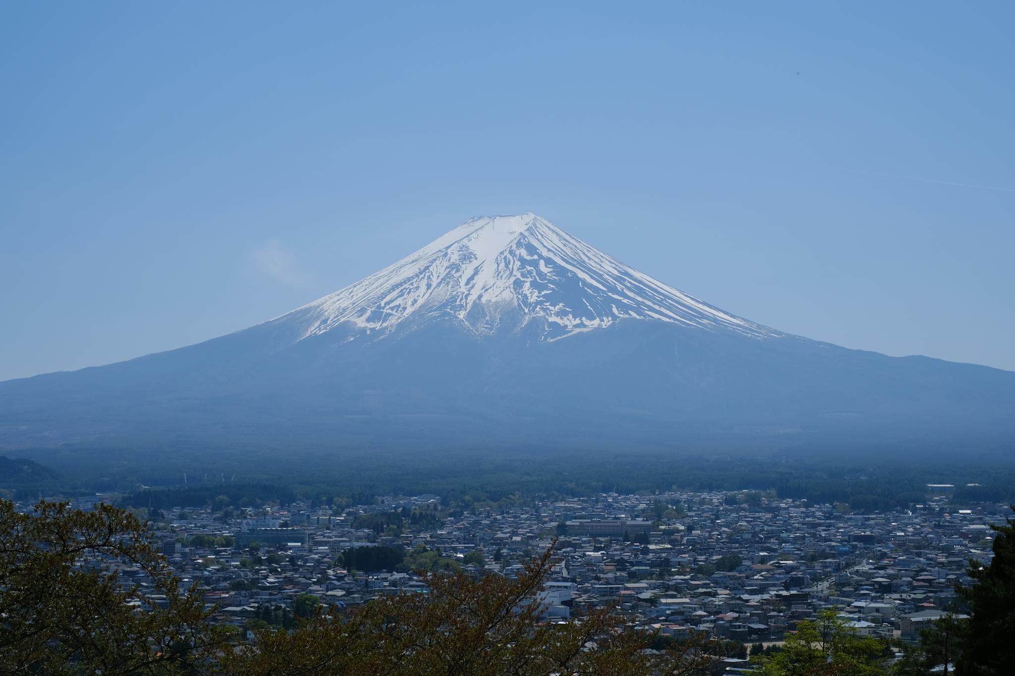 Beautiful view of Mount Fuji with a clear blue sky above suburban Japan.